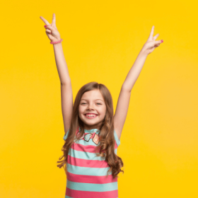 girl with arms up smiling
