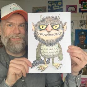 Olaf Falafel holding up artwork of a children's book monster